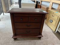 Front view of Hooker bedside table showing three drawers and decorative columns.