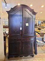 Front view of the two-piece Paula Deen wood bar cabinet, showing top and bottom parts with doors and drawers.