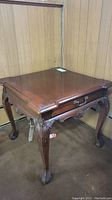 Full view of the solid wood square side table showing wood surface, carved legs, and drawer.