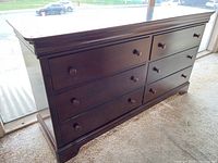 Front-left angle view of the six-drawer dark wood dresser showing drawer arrangement and wood pulls.
