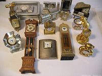 Overview of the 14 mini clocks showing a mix of metal, wood, and crystal designs plus variations in shapes including animals and novelty forms.