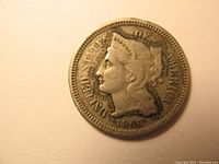 Obverse side of the 1865 Three Cent Nickel coin showing Liberty head and date.