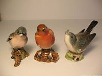 Photo showing all three Beswick bird figurines together on a flat surface against a plain background; the Chaffinch, Robin, and Early Whitethroat models are visible.