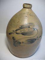 Full view of the large 2 gallon stoneware jug showing its overall shape, blue painted decoration, and handle.