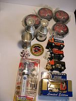 Photo showing four sealed McDonalds 2002 hockey pucks with Wayne Gretzky, three silver-tone metal Stanley Cup cups, a PEZ Stanley Cup dispenser, Valeri Bure trading card, a hockey pog in original packaging, and four White Rose Zamboni toy vehicles with one boxed.