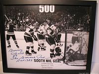 Framed black and white photo showing the moment Bobby Hull scored his 500th NHL goal, autographed with blue marker in the lower left corner.