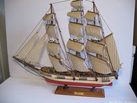 Full view of the triple mast clipper ship model on its stand showing sails, rigging, and hull details.