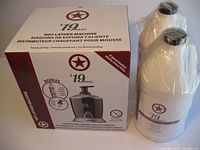 Photo of Wahl 19 Hot Lather Machine boxed product and two large sealed jugs of liquid lather in white bottles wrapped in plastic.