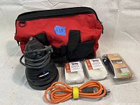 Black & Decker 6-inch polisher, power cord, felt pads, polishing sponge, and red carrying bag arranged on a white background.