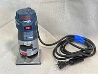 Front view of Bosch Colt PR20EVS palm-grip router showing power switch, brand logo, and power cord taped for storage.