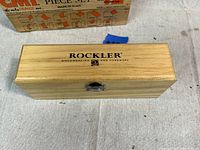 Closed Rockler wooden box with logo on lid, natural finish with metal latch.