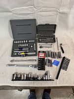 Full display of Craftsman socket and wrench set including multiple ratchets, sockets, wrench, extensions, and adapter pieces arranged on a white surface.