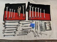 Overview photo of entire wrench lot organized on cloth with wrenches and pliers visible