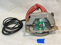 Front-side angle of Milwaukee 6365 circular saw showing red handle, silver blade guard with Milwaukee logo, and attached power cord.