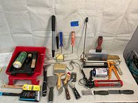 Full lot of painting tools and supplies arranged on white background including trays, brushes, rollers, scrapers, caulking guns and mixers