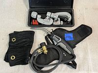Overall lot showing Ridgid pipe cutters in case next to Bernzomatic torch, hose, and black carrying pouch.