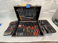 Full view of open case showing upper flap with screwdrivers, middle tray with pliers and lower tray with cables