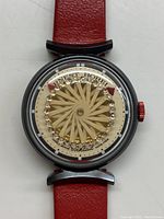 Watch face and red leather strap centered on white background