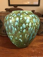 Front full view of vintage rounded ceramic vase with green and turquoise glaze and organic drip patterns.
