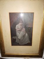 Front view of antique gouache painting depicting a woman in white dress holding baby, glass covered, wood framed with gold finish.