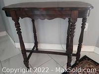 Front view of antique walnut sofa table showing turned legs, scalloped apron, and rectangular top.