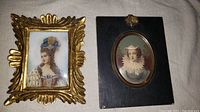 Photo showing two antique miniature portraits: one of Marie Antoinette in a gilt frame and one of Queen Elizabeth I in a black wood mount
