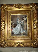 Miniature gouache painting of Marie Antoinette in a white dress with blue ribbons, framed in ornate gold frame, showing full painting and frame.
