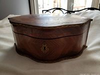 Front view of the wooden box showing intricate marquetry and brass keyhole escutcheon.