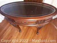 Photo of the oval wooden sofa table with a glass top showing the overall appearance and condition.