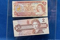 Front side of 1974 and 1986 Canadian $2 bills featuring Queen Elizabeth II.