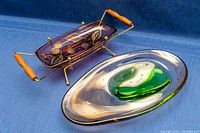 Purple rectangular serving dish with gold leaf design on a brass atomic holder with wooden handles, shown from side angle