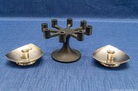 Front and side view of the black cast iron multi-candle holder and two stainless steel tapered candleholders