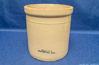 Front view of the cream-colored Medalta crock with maker's mark