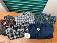 Five L.L. Bean men's flannel shirts laid out on table showing various plaid patterns and colors, confirming quantity and style.