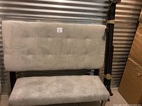 Full view of gray velour padded headboard and tufted bench under indoor lighting, showing tufted button details and bed frame parts.