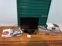 Full view of the lot including Philips DVD player, Sharp 15-inch TV, Philips DVD/VHS player, Sony clock radio, all placed on a table