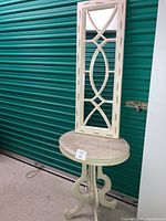 Full view of pale green vintage side table with marble top and off-white vintage mirror placed on top, showing overall appearance and condition.