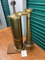 Overall view of foghorn assembled on wooden base, with cylinder, handle and horn visible