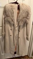 Front view of cream-colored vintage cashmere coat with wide fur collar and button closure