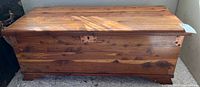 Full view of the rectangular cedar chest with wood grain finish and flat lid.