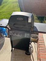 Front view of Huntington Cast grill with lid closed, showing lid handle and side shelves.