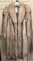 Full front view of coat on hanger showing floor-length design, shawl collar and long sleeves