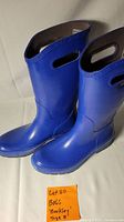 Front angle view of pair of blue Bogs rain boots with visible cut-out handles and size sticker