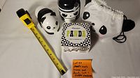 Photo showing three panda bento boxes, the panda salt and pepper shaker set box, the panda pouch, and a measuring tape for scale.