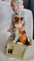 Side view of the Royal Doulton veterinarian figurine holding a sheepdog, showing detailed painting and porcelain finish
