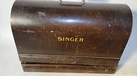 Bentwood carrying case with visible wear and Singer branding on front.