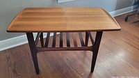 Front view of the rectangular teak side table showing smooth tabletop and tapered legs.