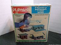 Front of Playskool Original Lincoln Logs boxed set showing a girl playing and images of sample builds.