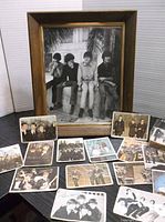 Photo of framed black and white 8x10 photo of The Beatles with multiple trading cards spread out in front.