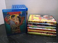 Set of 15 Blu-ray and DVD movie cases stacked and arranged showing Crazy Rich Asians in front.